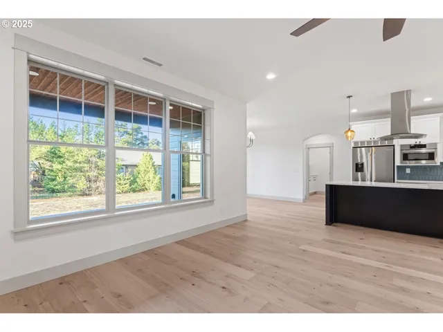 a view of empty room with wooden floor and windows