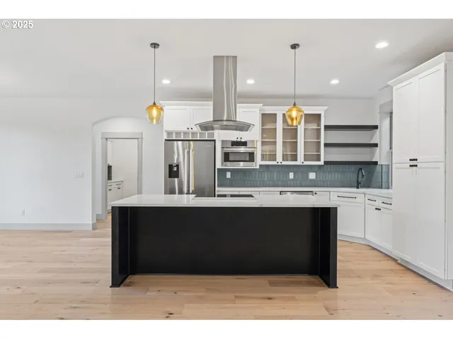 a kitchen with kitchen island stainless steel appliances a sink and cabinets