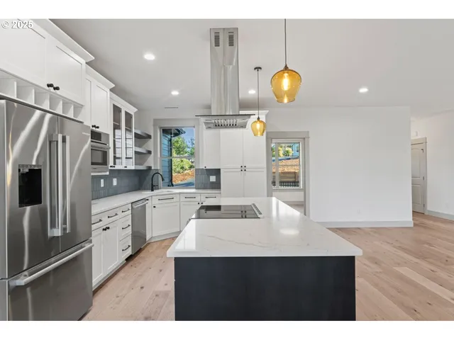 a kitchen with a sink stainless steel appliances and white cabinets