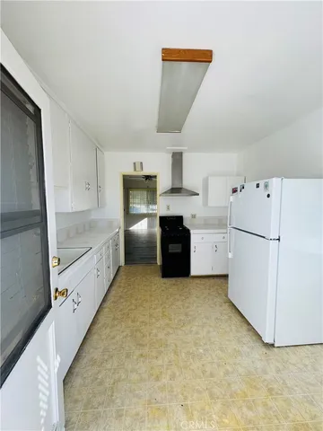 a large kitchen with a stove a refrigerator and a sink