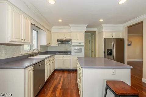a kitchen with kitchen island a sink stove and refrigerator