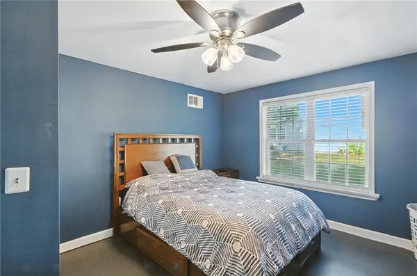 a bedroom with a large bed and a chandelier