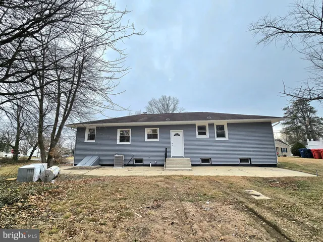 a front view of house with yard and trees in the background