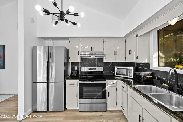 a kitchen with a sink stainless steel appliances and cabinets