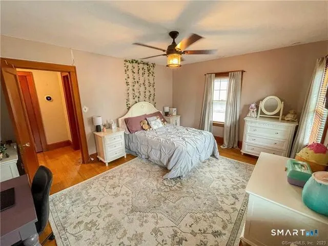 a bedroom with a bed window and a flat screen tv