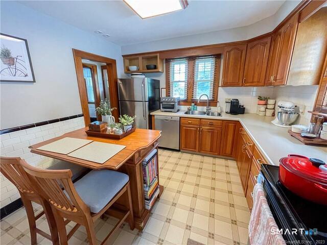 16 Meriden Avenue Meriden, CT 06451 - Photo 9 of 29 a kitchen with a table chairs and wooden cabinets