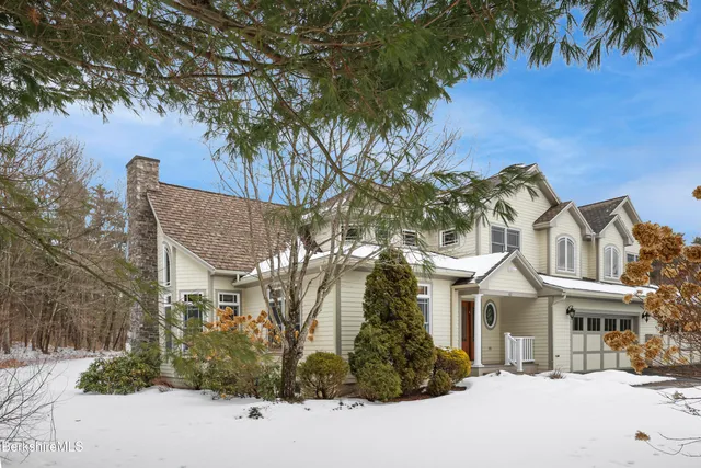 a front view of a house with a tree