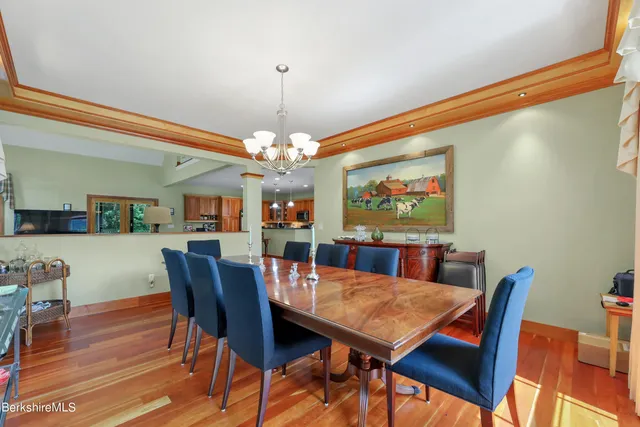 a view of a dining room with furniture a chandelier and wooden floor