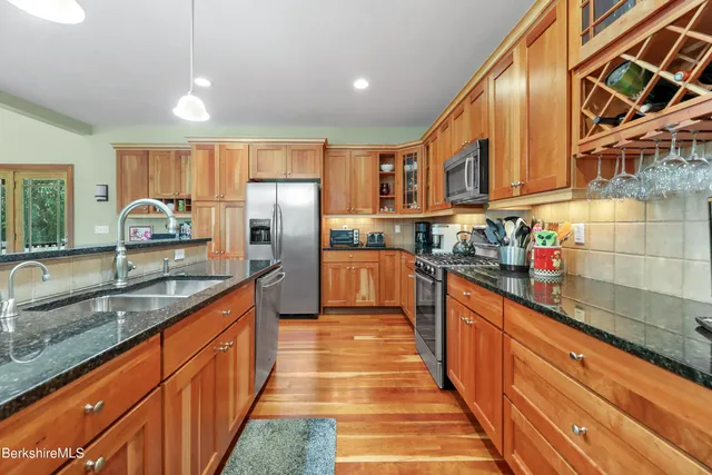 a large kitchen with stainless steel appliances granite countertop a sink and counter space