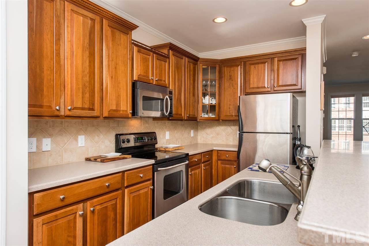 3517 Edgemont Drive Raleigh, NC 27612 - Photo 9 of 25 a kitchen with stainless steel appliances granite countertop a sink a stove and a refrigerator with wooden floor
