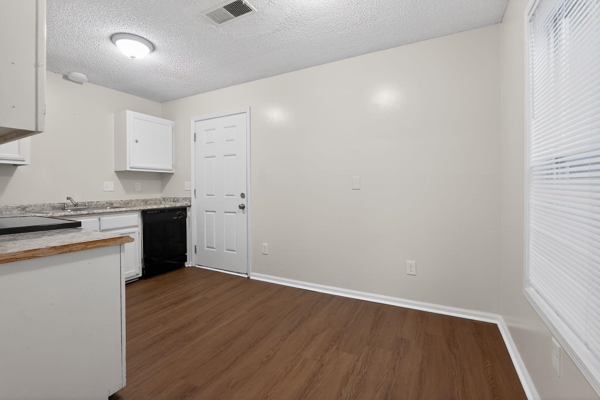 4725 Lofts Road Memphis, TN 38118 - Photo 15 of 32 Kitchen with a textured ceiling, white cabinetry, dark wood-type flooring, and black dishwasher