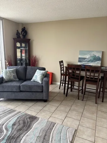 a living room with furniture a dining table and a window