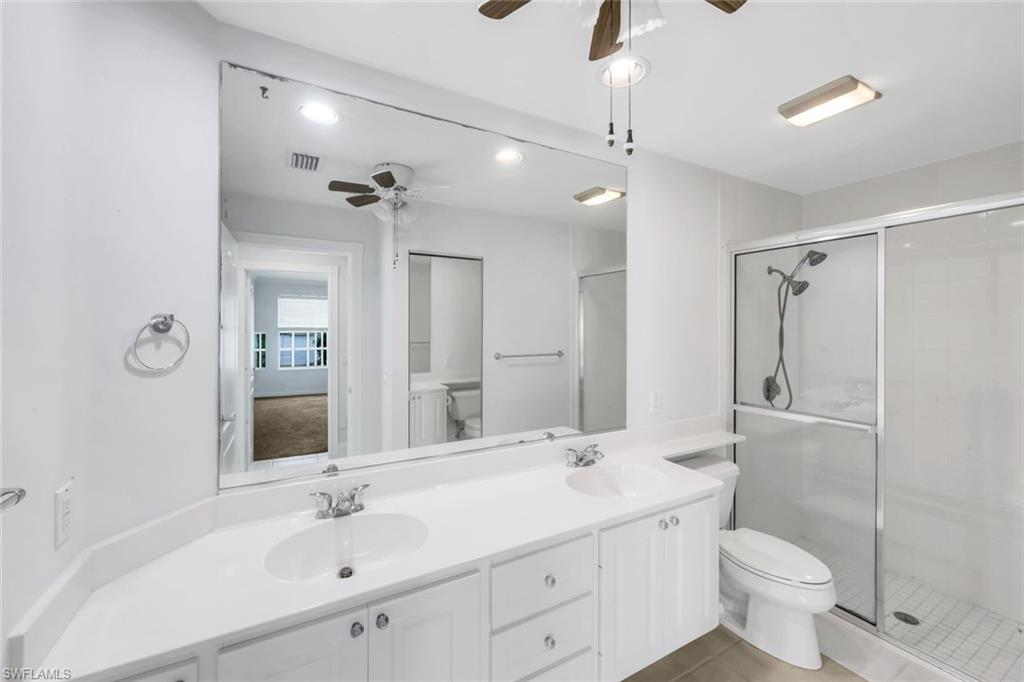 3748 Exuma Way Naples, FL 34119 - Photo 18 of 50 Primary Bathroom with double vanity, a stall shower, recessed lighting, light tile patterned floors, and a ceiling fan