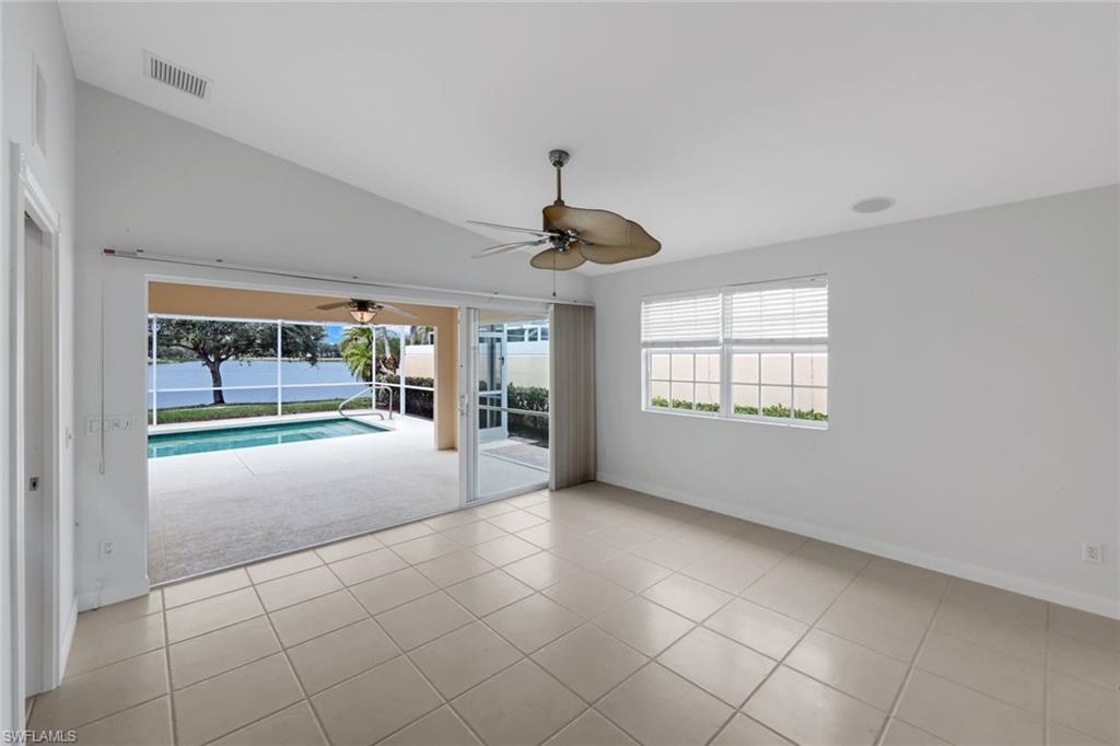 3748 Exuma Way Naples, FL 34119 - Photo 23 of 50 Living room featuring a west facing water view, vaulted ceiling, a ceiling fan, and lanai. Relax from the comfort of your living area to your private pool and sunsets.
