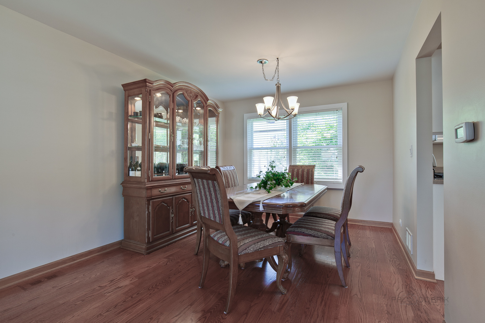 1300 Devonshire Road Buffalo Grove, IL 60089 - Photo 9 of 34 a view of a dining room with furniture a chandelier and wooden floor