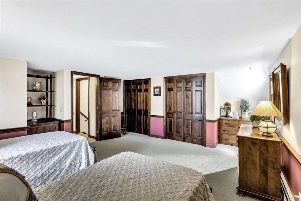 56 Danas Path Yarmouth, MA 02673 - Photo 30 of 32 a bedroom with a bed and dresser with mirror