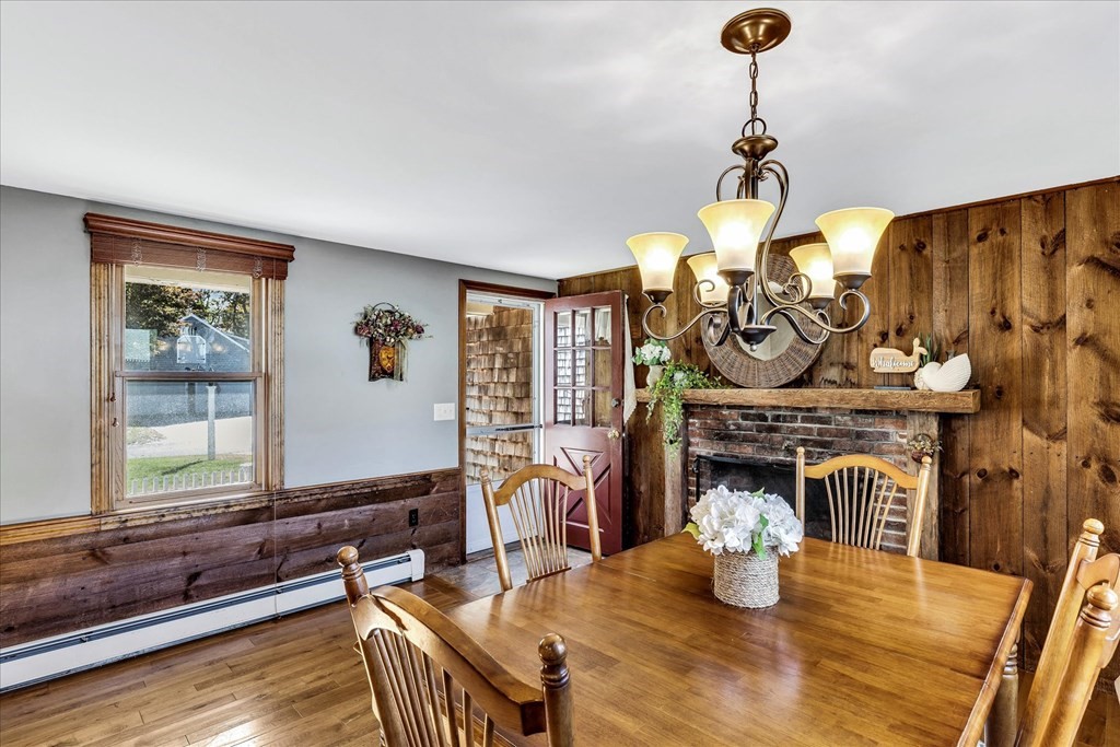 56 Danas Path Yarmouth, MA 02673 - Photo 6 of 32 a dining room with furniture a fireplace and wooden floor