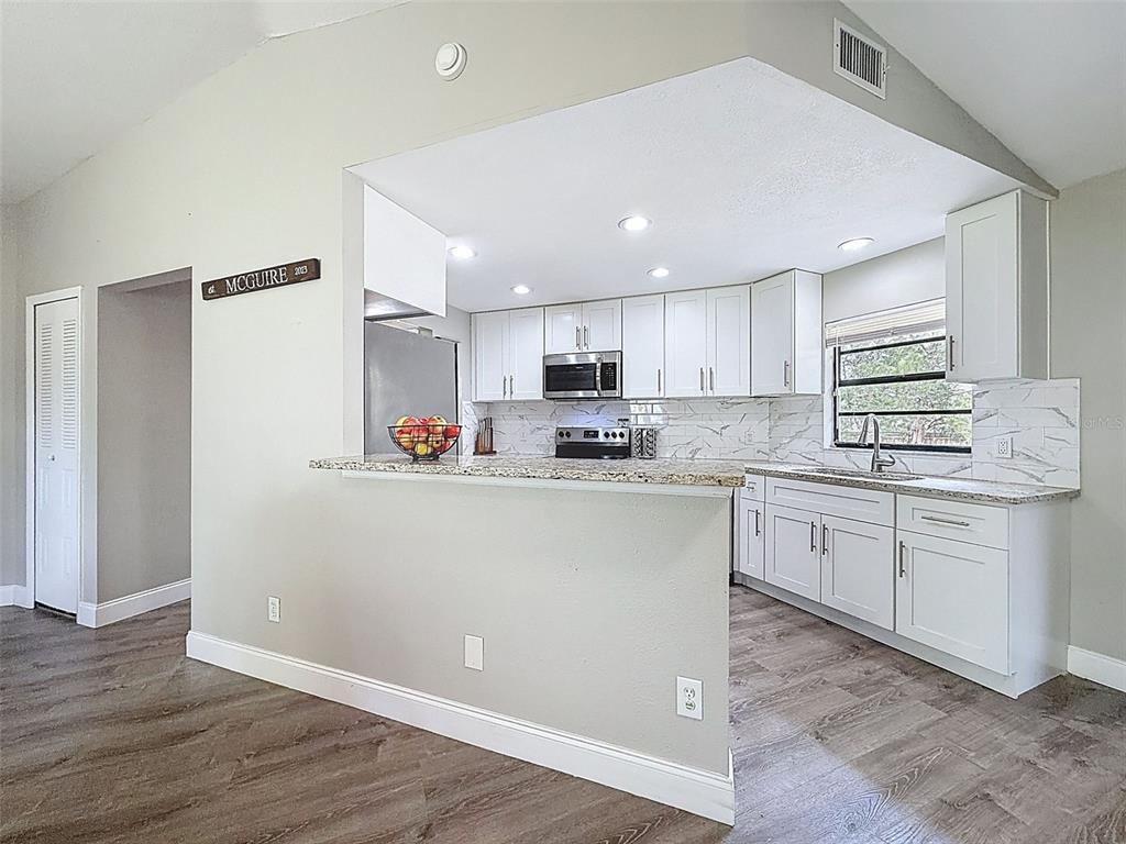 5384 Baldock Avenue Spring Hill, FL 34608 - Photo 21 of 51 a kitchen with granite countertop white cabinets and white appliances
