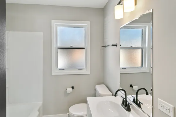 a bathroom with a sink vanity mirror and toilet