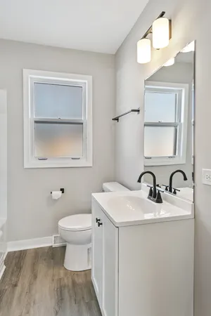 a bathroom with a toilet sink and mirror
