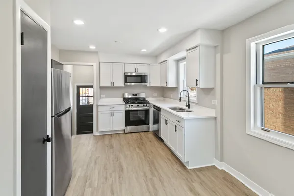 a kitchen with stainless steel appliances a refrigerator sink and cabinets