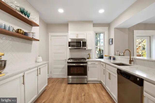 a kitchen with granite countertop a sink and steel appliances