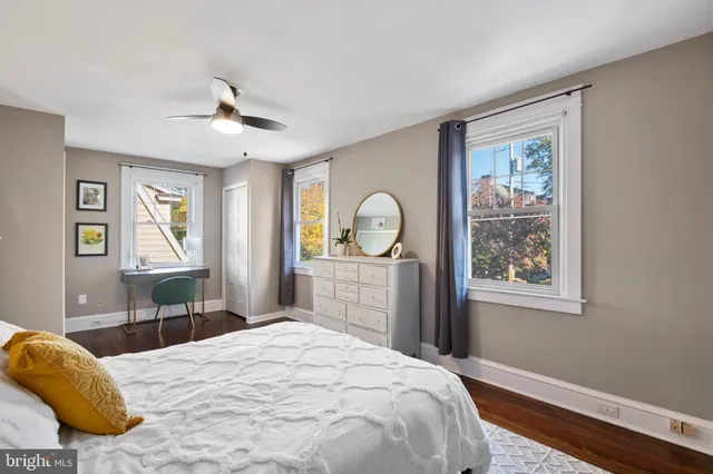 a bedroom with a bed and dresser with mirror