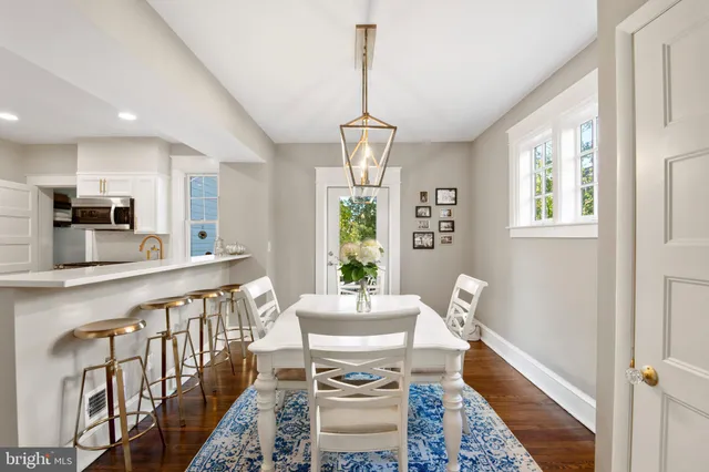 a dining room with furniture a chandelier and wooden floor
