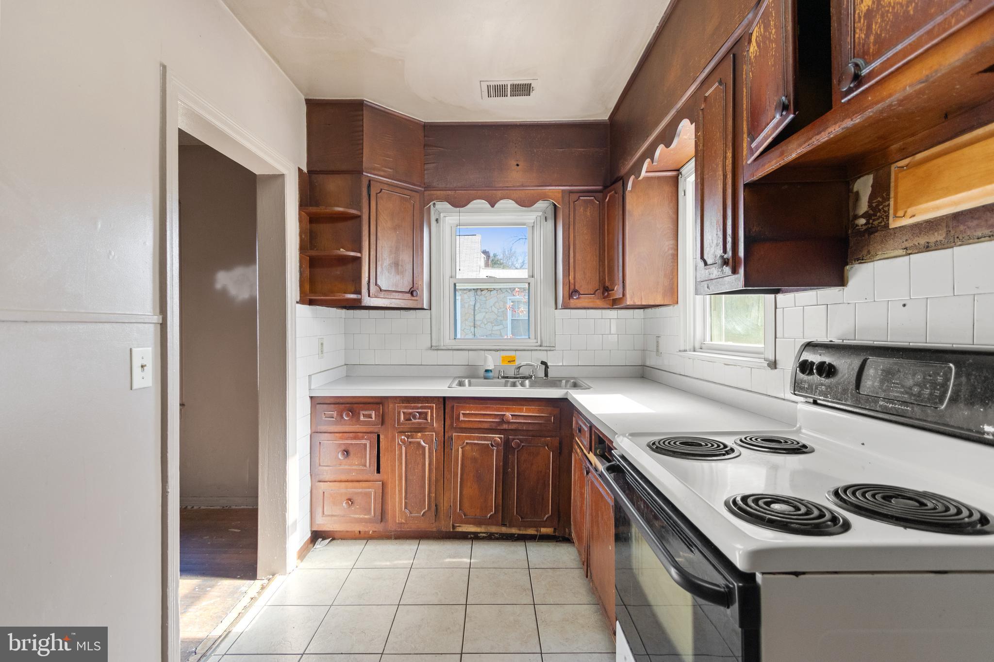 6009 Old Silver Hill Road District Heights, MD 20747 - Photo 13 of 24 a kitchen with stainless steel appliances granite countertop a stove a sink and a refrigerator