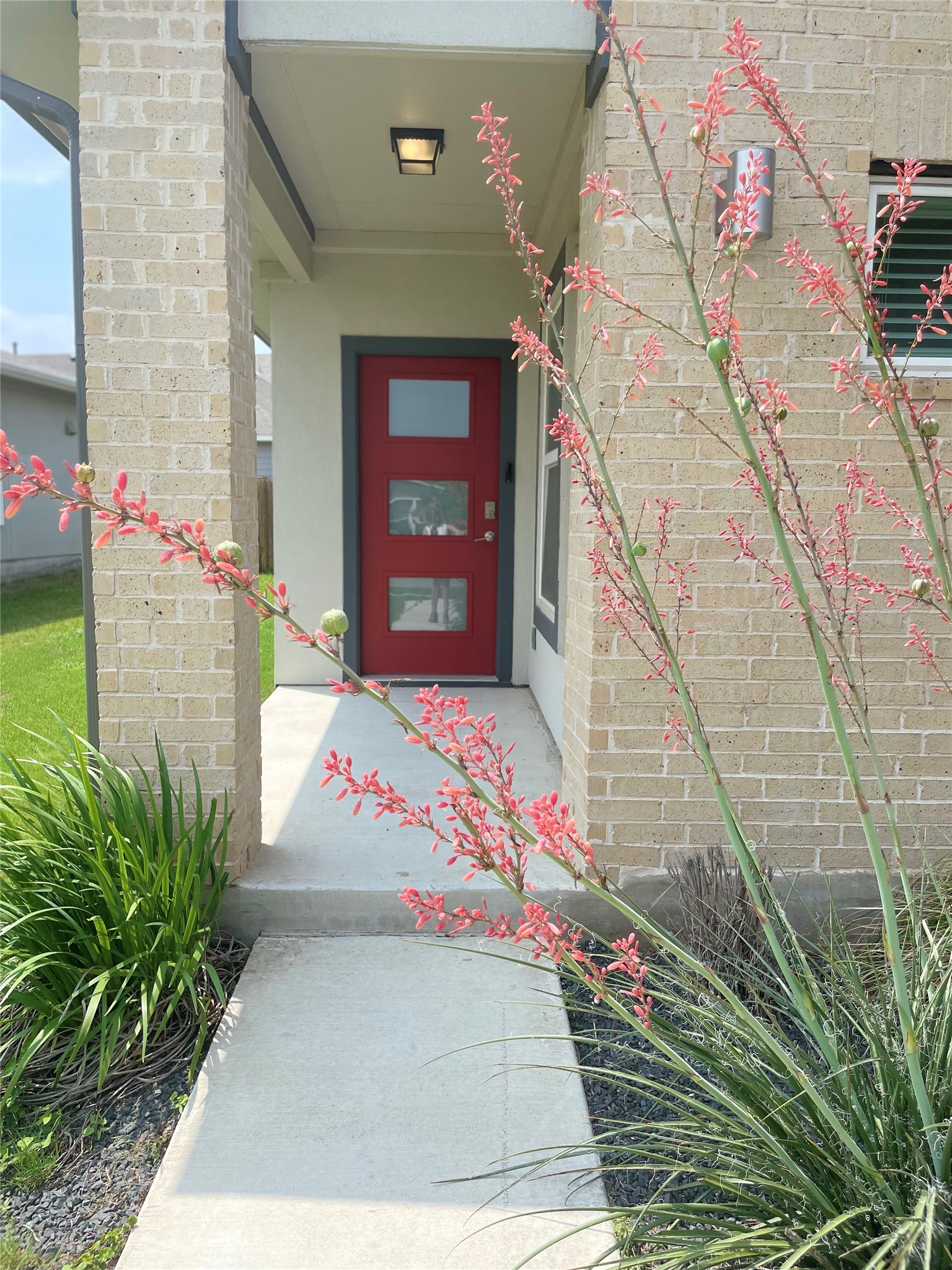 5128 Vanner Path Georgetown, TX 78626 - Photo 2 of 20 Modern red entry door with three rectangular lites, set within a brick facade and stucco column