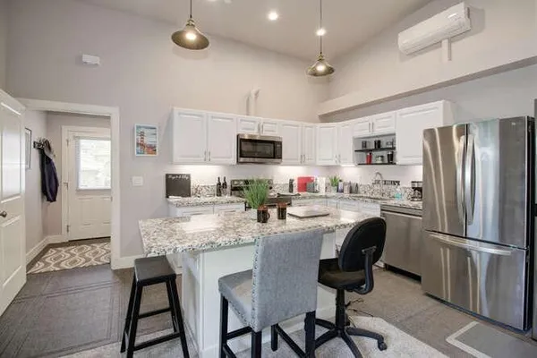 a kitchen with refrigerator and chairs