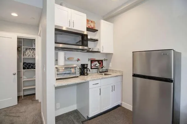 a kitchen with stainless steel appliances a refrigerator sink and microwave