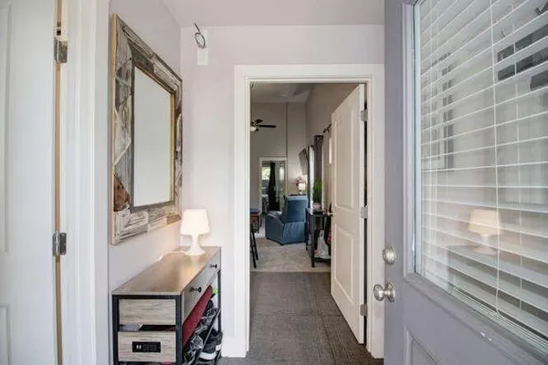 a view of a hallway and a livingroom with furniture