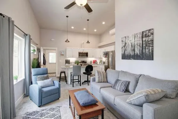 a living room with furniture kitchen and a chandelier