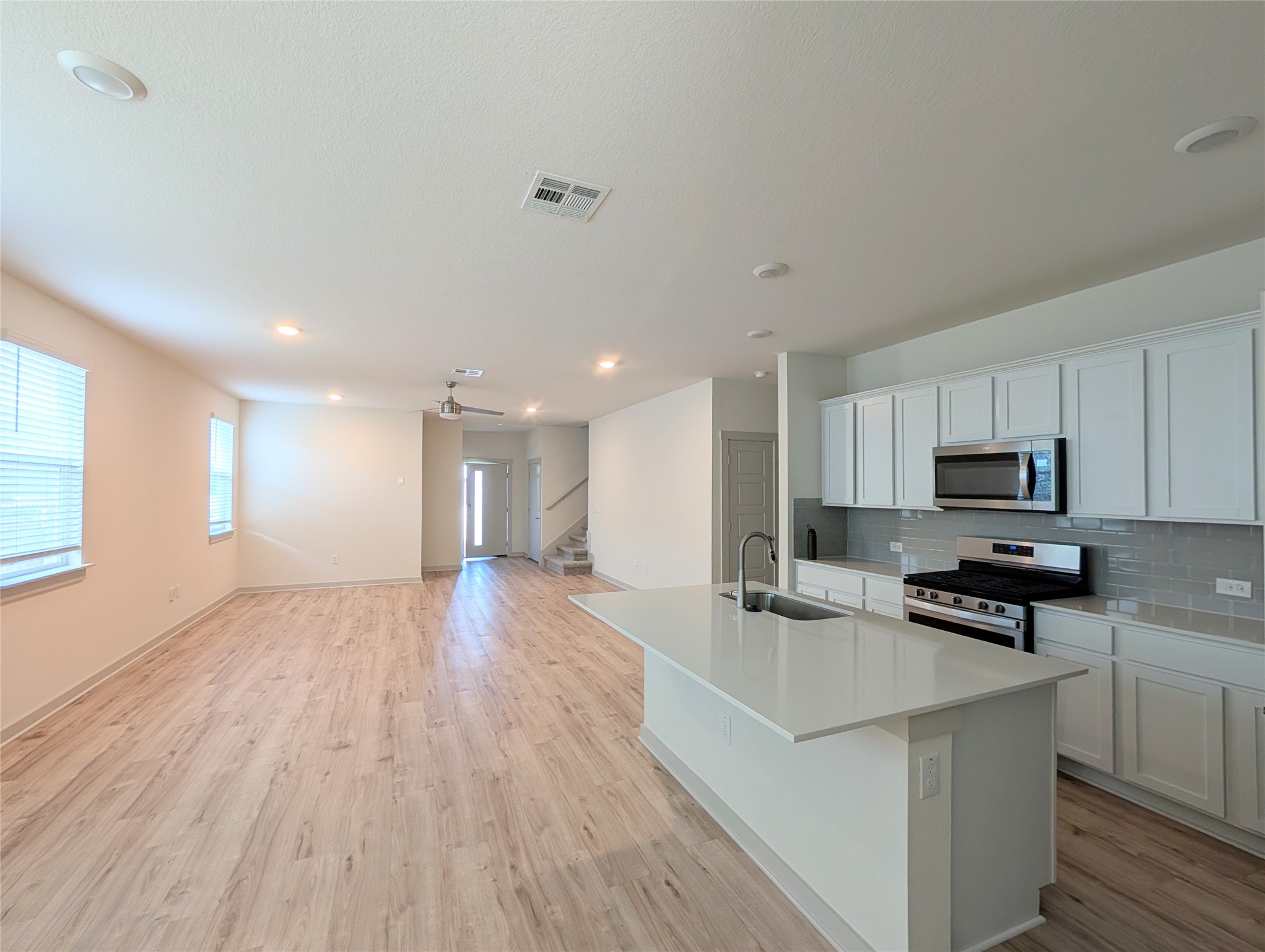 261 Century Plant Road Leander, TX 78641 - Photo 5 of 25 An open-concept living space with a modern kitchen island and light wood flooring.