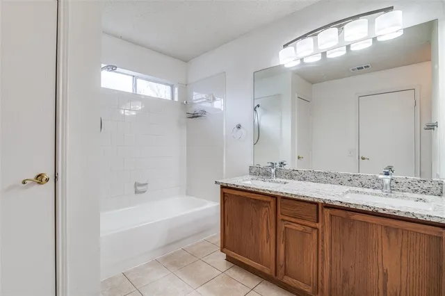 a bathroom with a granite countertop sink mirror and a bath tub
