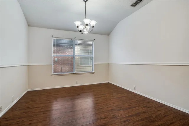 a view of wooden floor chandelier and window in a room