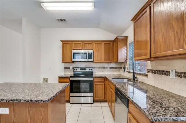 a kitchen with stainless steel appliances granite countertop a sink stove and cabinets