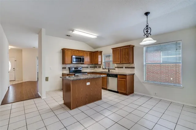 a kitchen with stainless steel appliances granite countertop a stove top oven a sink a counter top space and cabinets