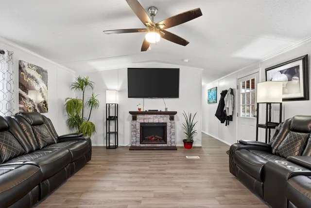 a living room with furniture a fireplace and a flat screen tv