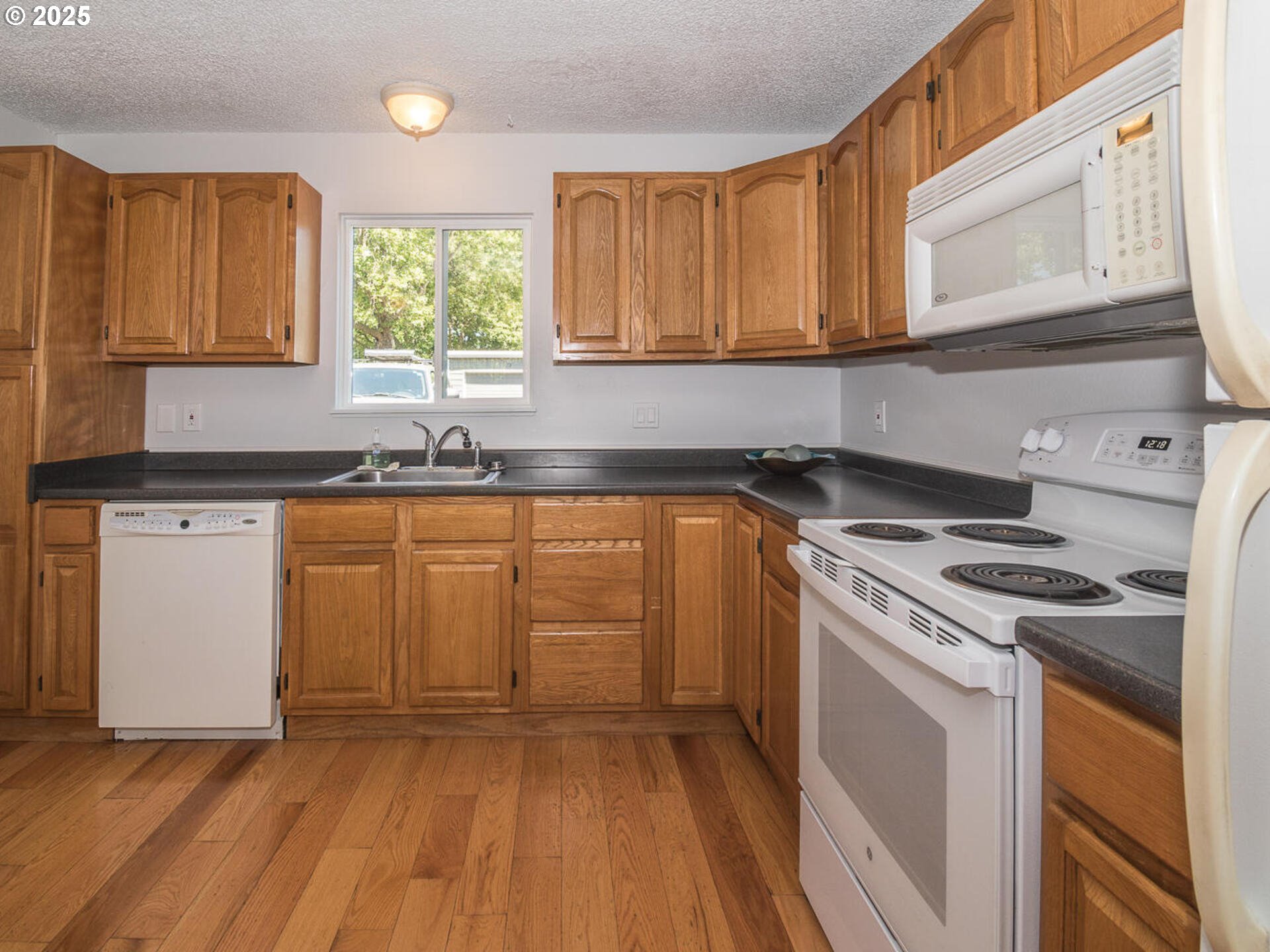 2712 Southeast 138th Avenue, Unit 53 Portland, OR 97236 - Photo 11 of 36 a kitchen with a sink a stove and cabinets
