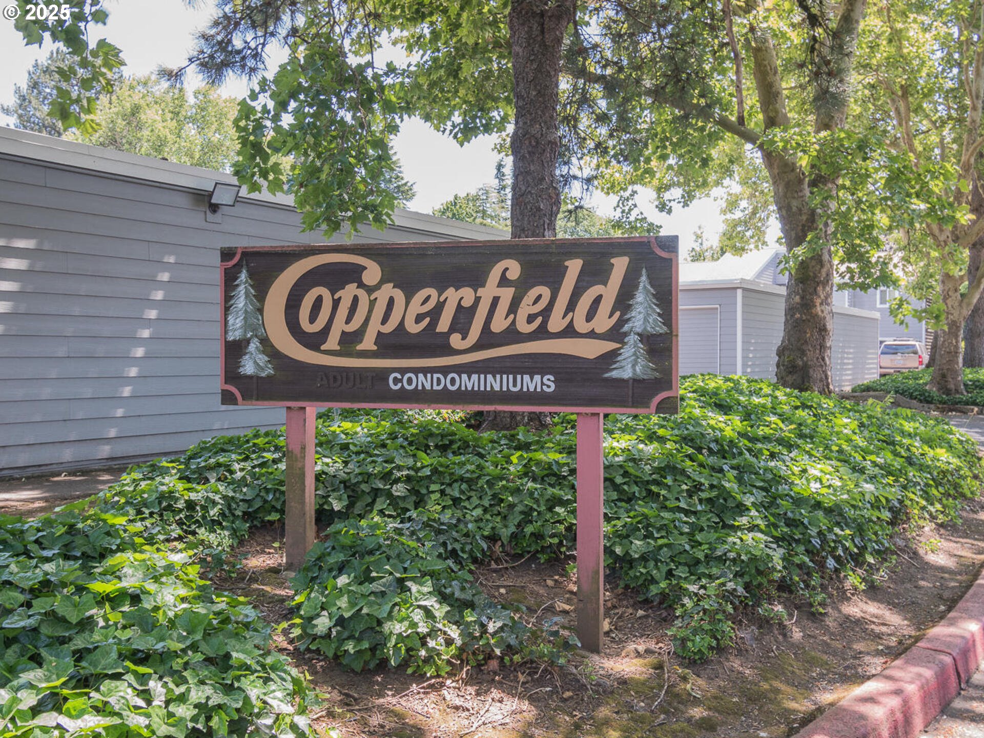 2712 Southeast 138th Avenue, Unit 53 Portland, OR 97236 - Photo 2 of 36 a sign broad in front of flowers