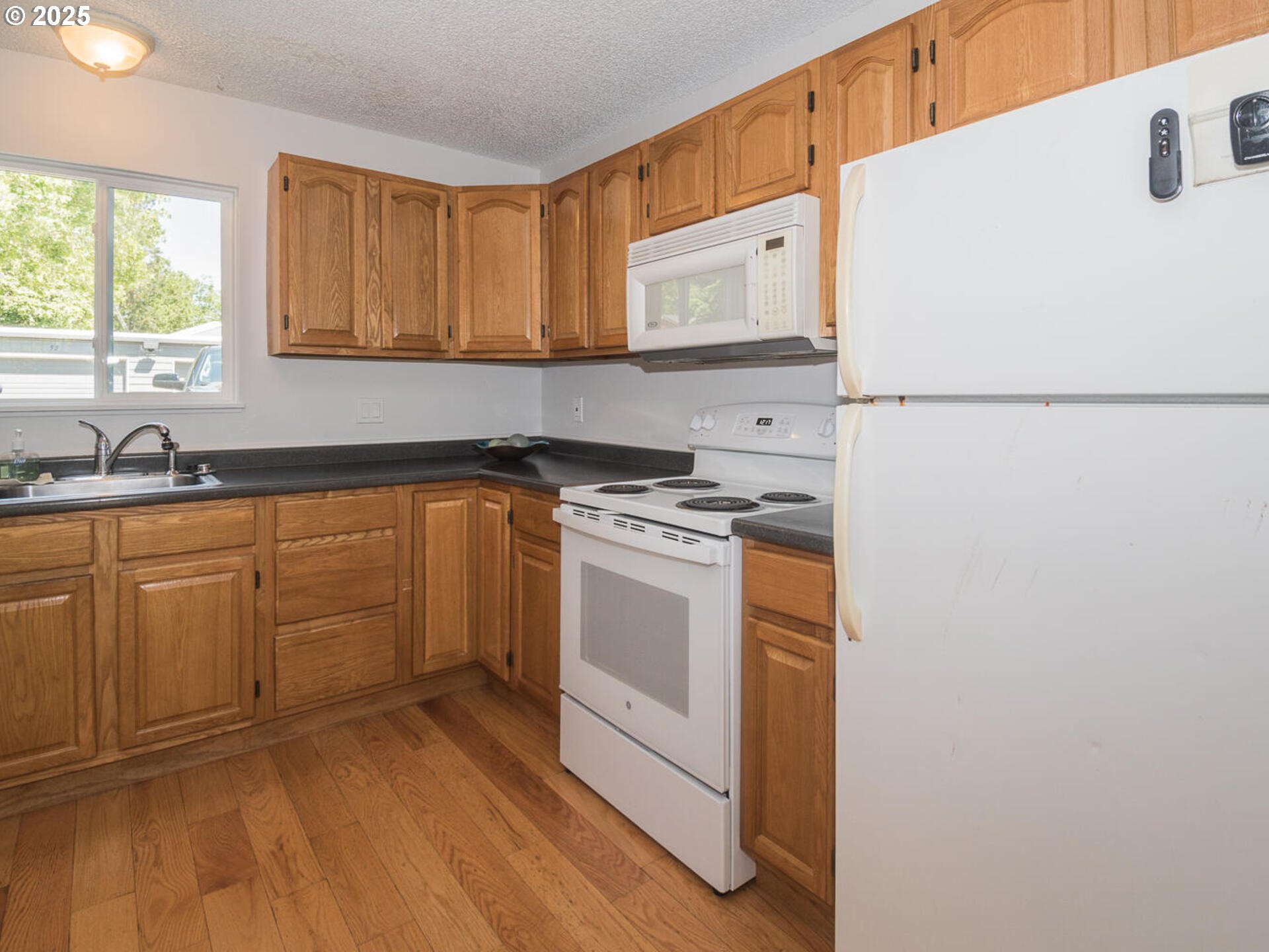 2712 Southeast 138th Avenue, Unit 53 Portland, OR 97236 - Photo 10 of 36 a kitchen with white cabinets and white appliances