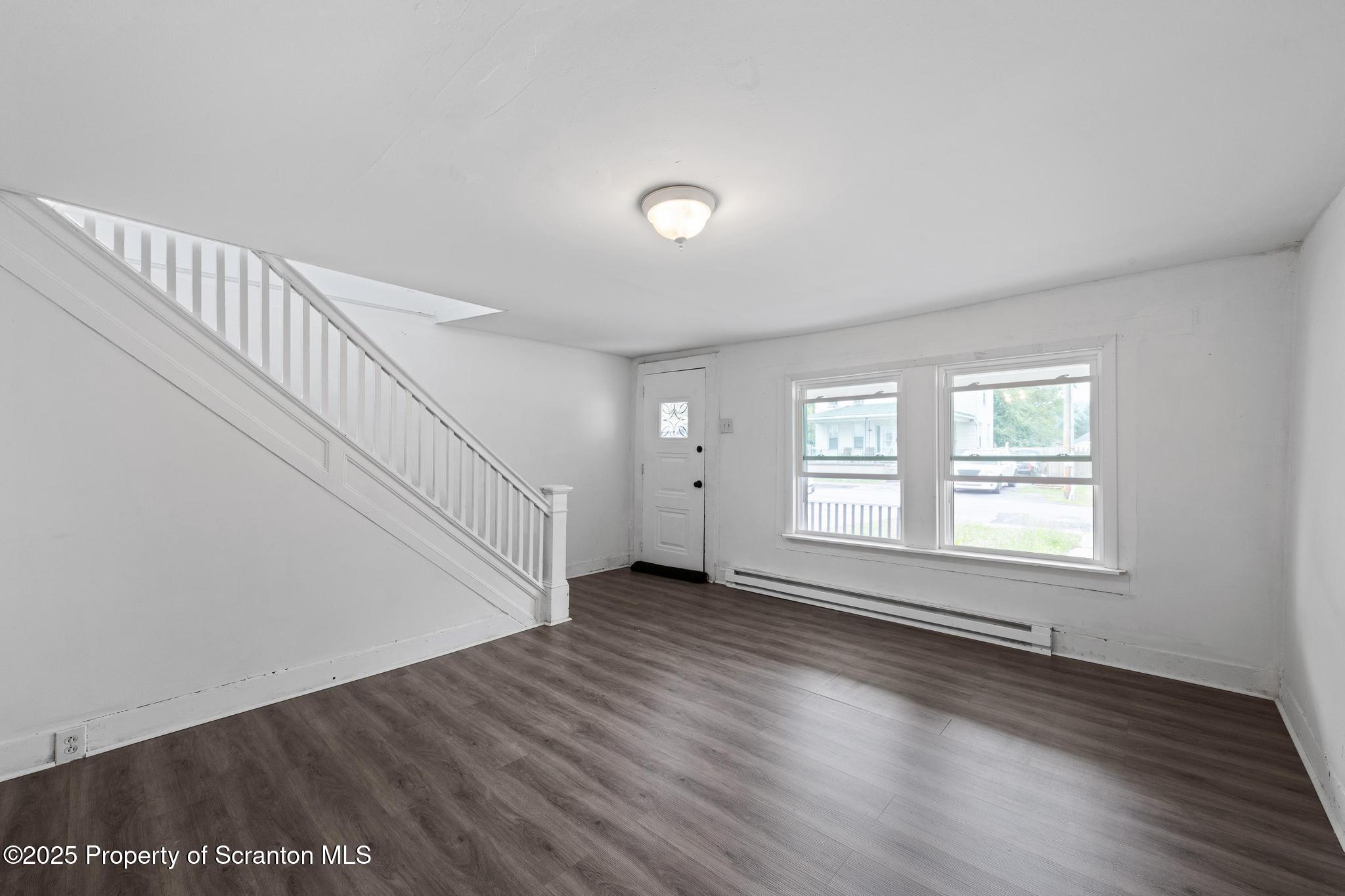 121 Throop Street Scranton, PA 18508 - Photo 16 of 37 a view of an empty room with wooden floor and a window