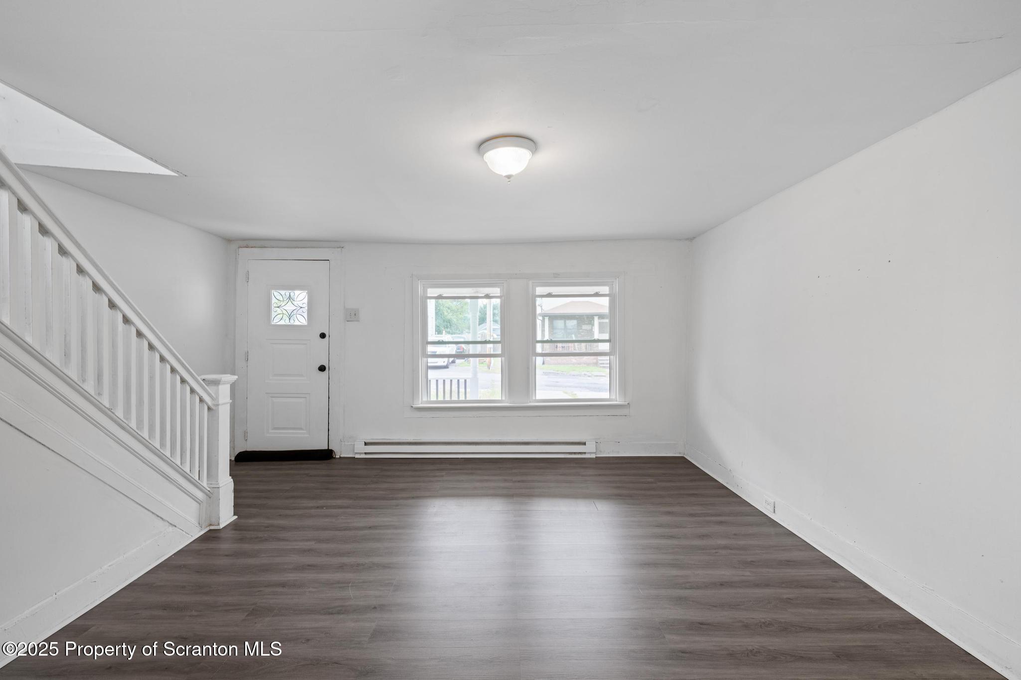 121 Throop Street Scranton, PA 18508 - Photo 17 of 37 a view of an empty room with wooden floor and a window