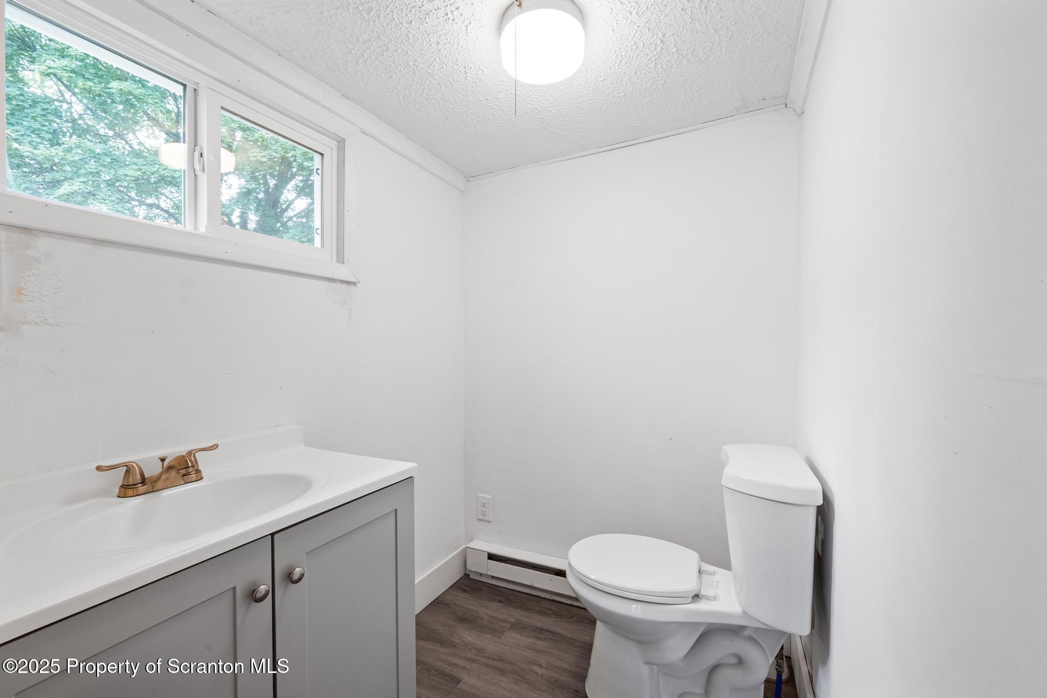 121 Throop Street Scranton, PA 18508 - Photo 19 of 37 a bathroom with a sink a toilet and a window