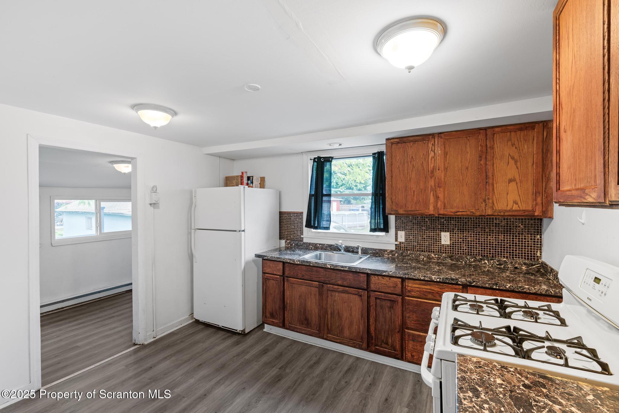 121 Throop Street Scranton, PA 18508 - Photo 22 of 37 a kitchen with granite countertop a stove a sink and a refrigerator