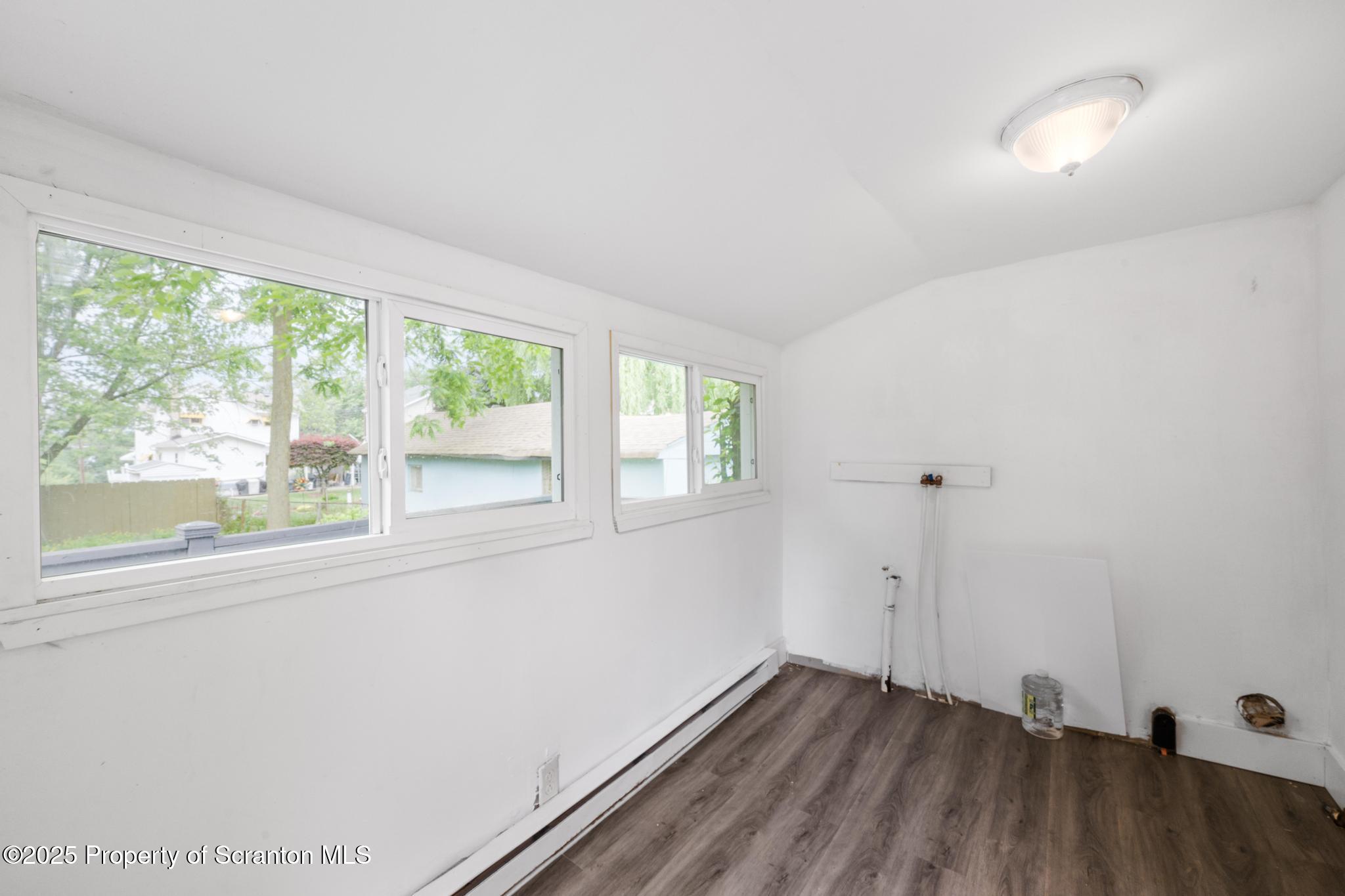 121 Throop Street Scranton, PA 18508 - Photo 26 of 37 a view of an empty room with wooden floor and a window