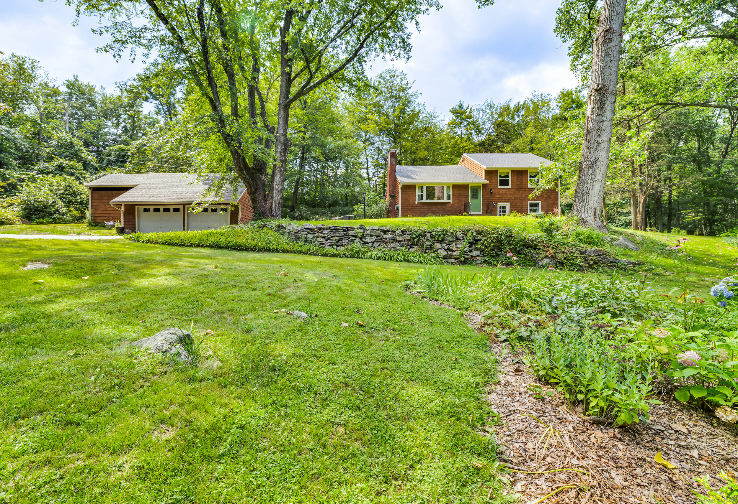 a front view of a house with a garden