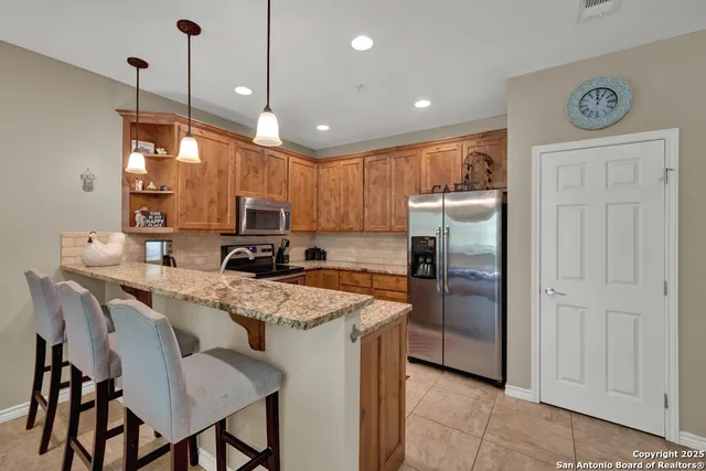 a kitchen with kitchen island a refrigerator stove microwave and cabinets